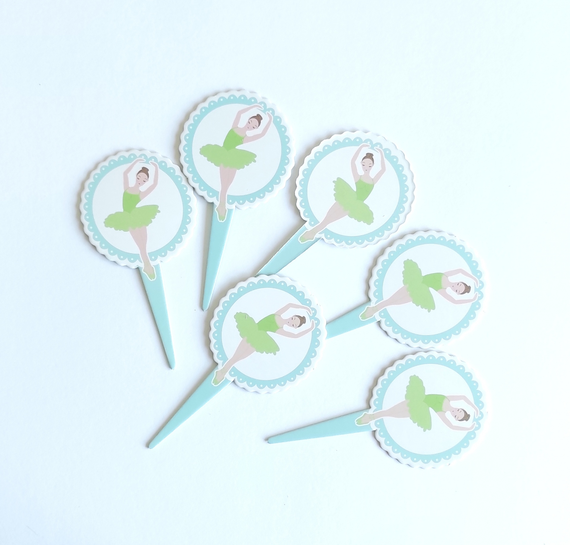 Apontadores de papel com figura de bailarina em saia verde e blusa branca sobre fundo branco e círculo azul