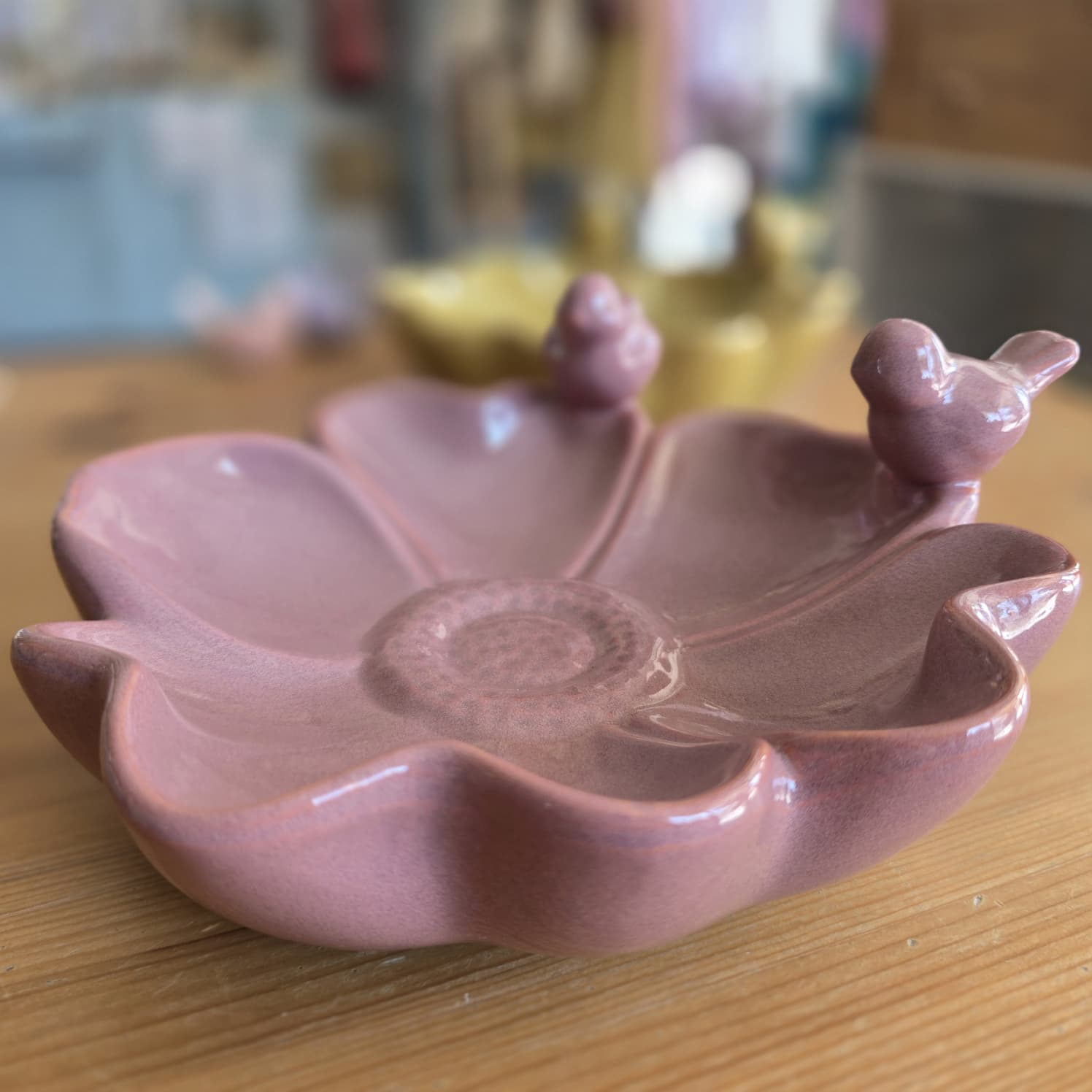 Prato decorativo rosa em cerâmica com forma de flor e pássaros nas bordas