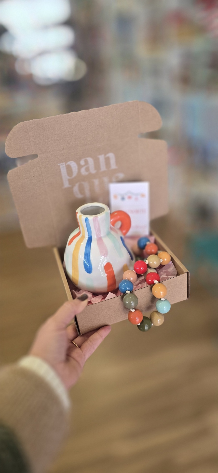 Caixa com vaso de cerâmica e colar de contas coloridas