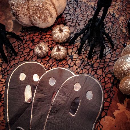 Decoração de Halloween com fantasmas pretos, abóboras douradas e rede preta.