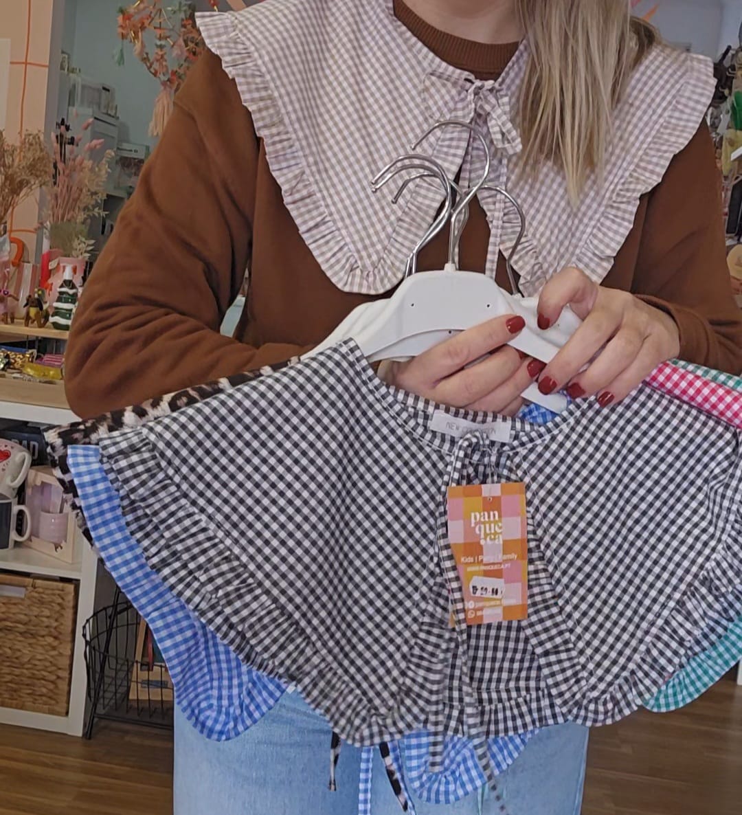 Mulher segura golas removíveis de tecido xadrez coloridos com acabamento franzido