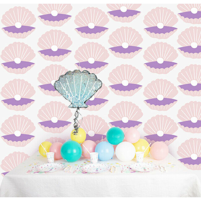 Mural com padrão de conchas, balão em forma de concha e mesa decorada com balões coloridos