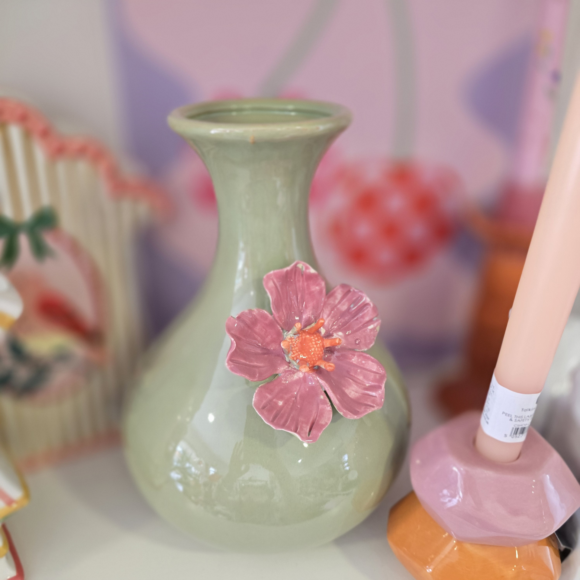 Vaso de cerâmica verde com flor rosa em relevo
