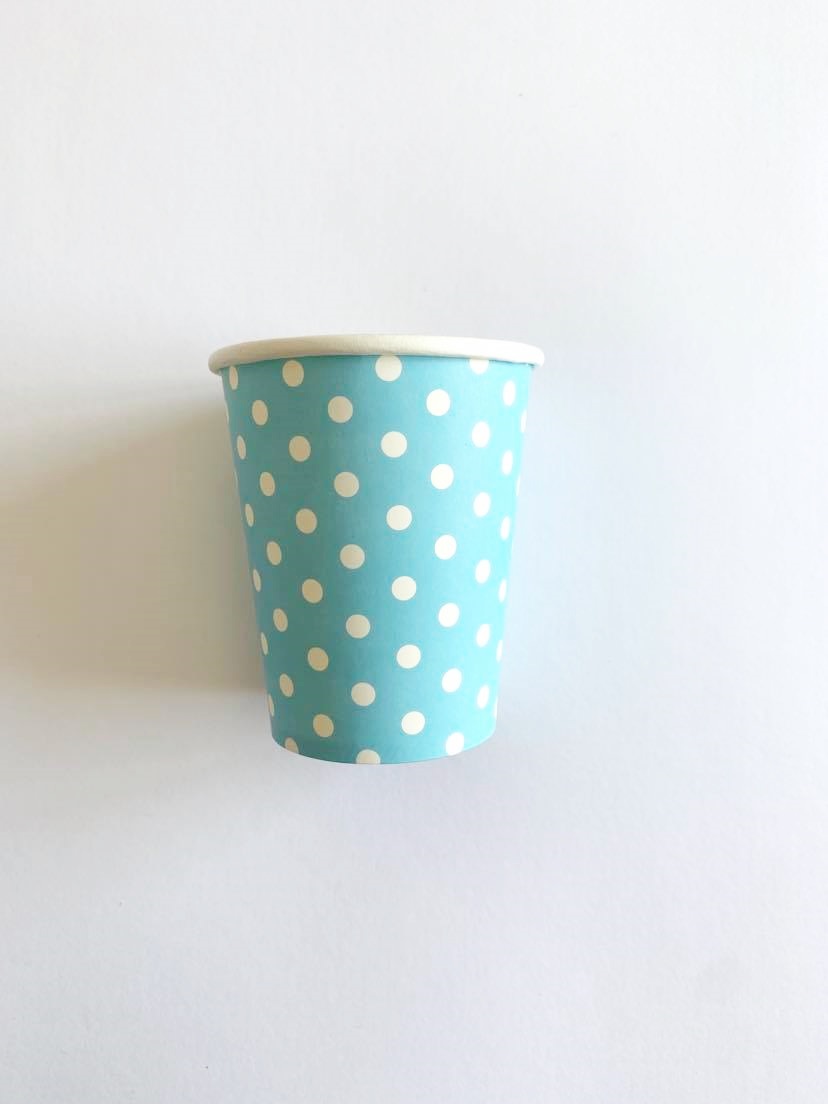 Copo de papel azul com bolinhas brancas sobre fundo branco