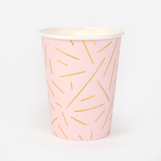 Copo descartável cor-de-rosa com riscas amarelas em fundo branco