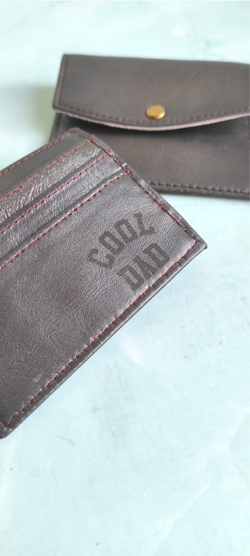 Carteira e estojo de couro castanho escuro com texto COOL DAD na carteira