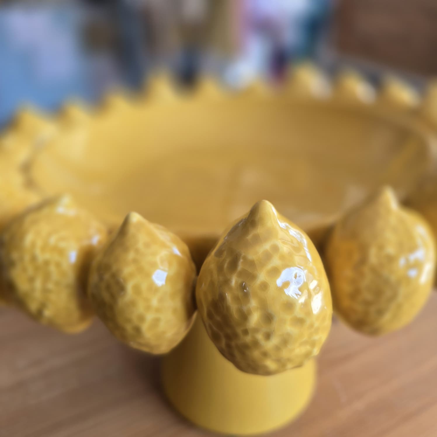 Fruteira amarela decorativa em cerâmica com formato de limões e textura martelada.