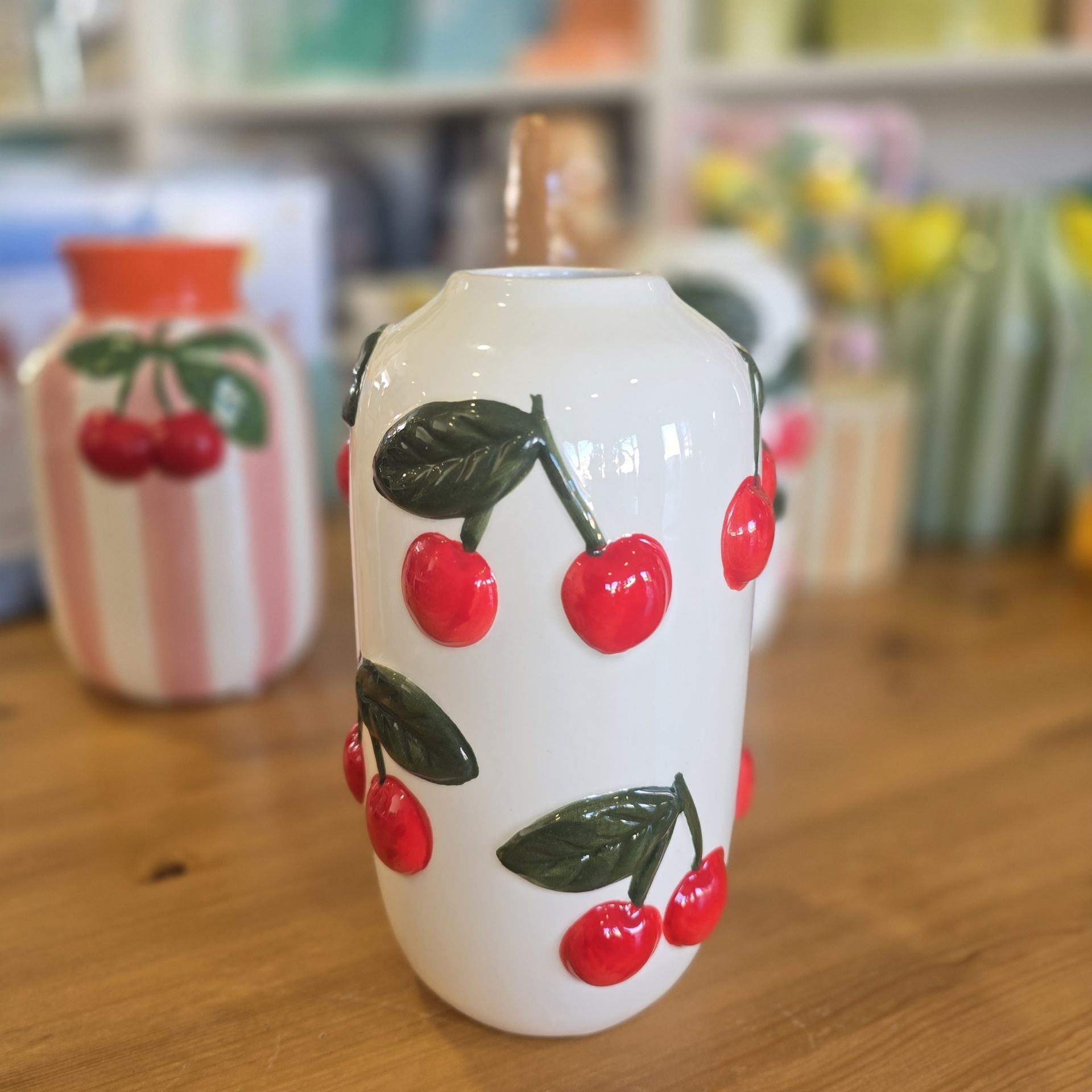 Vaso cerâmico branco com cerejas vermelhas em relevo