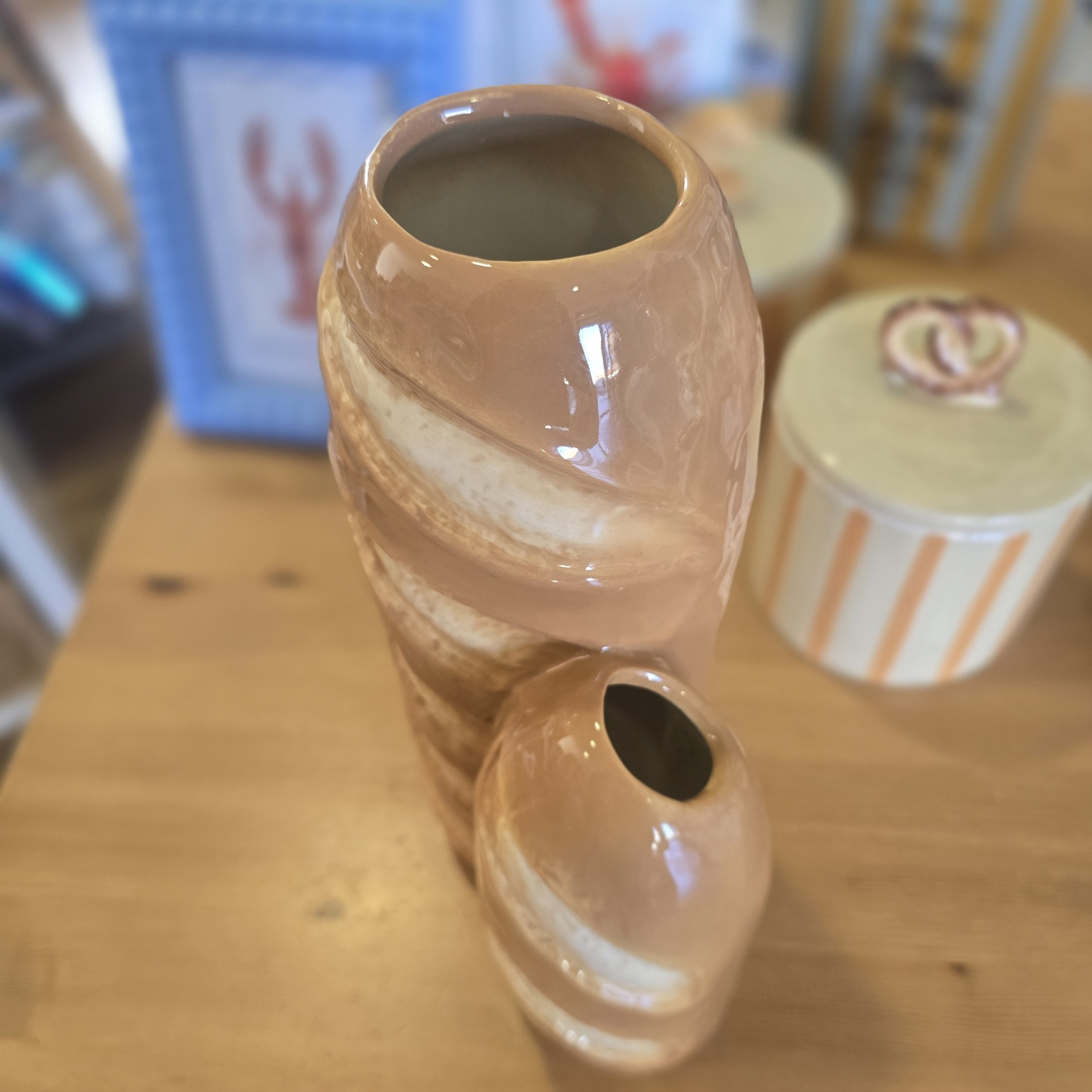 Dois vasos de cerâmica castanhos e creme sobre mesa de madeira.