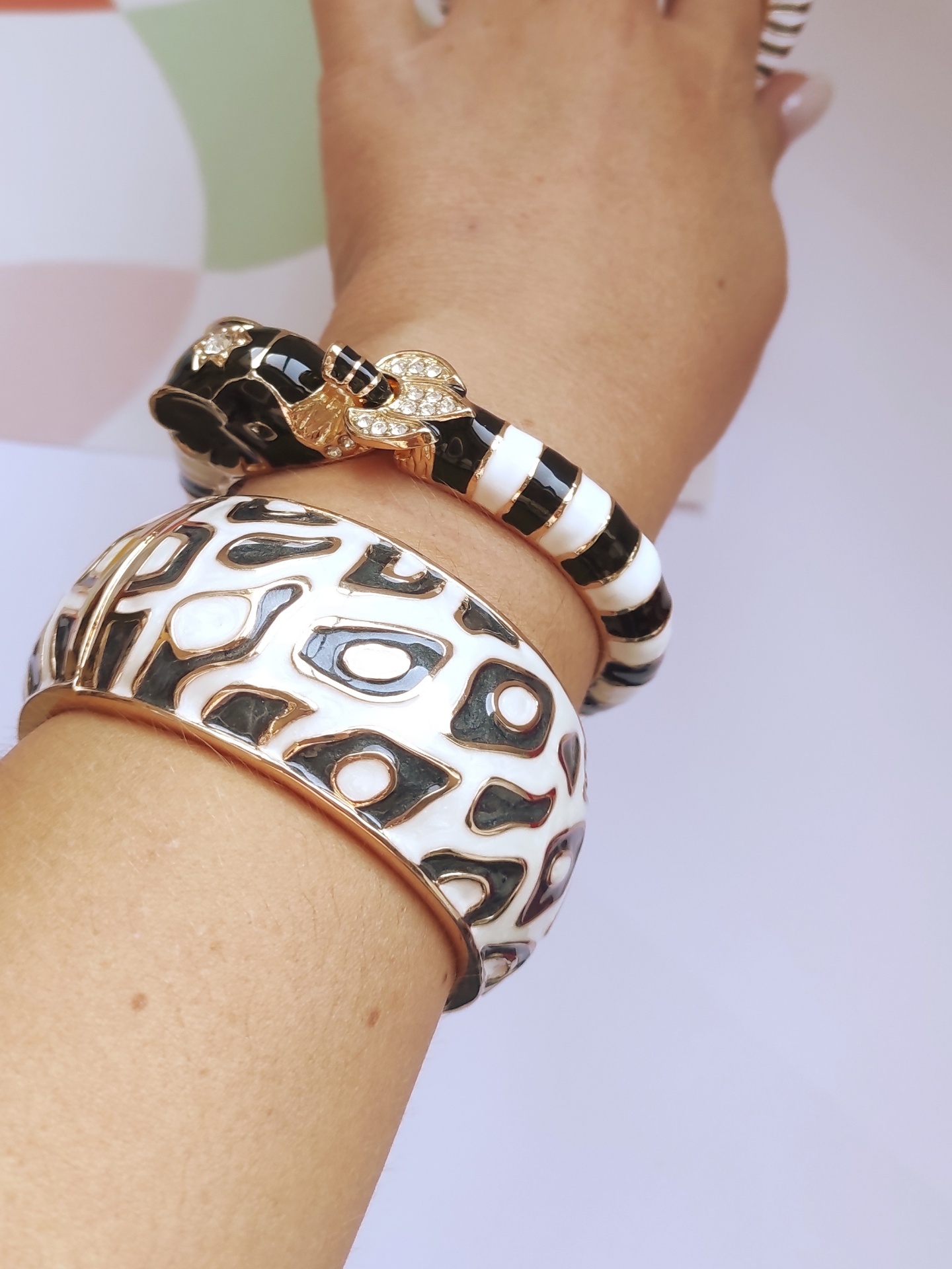 Pulseiras com padrões em branco, preto e dourado num pulso