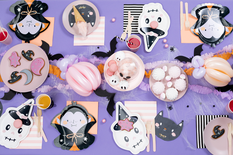Mesa decorada com pratos temáticos de Halloween e decoração colorida
