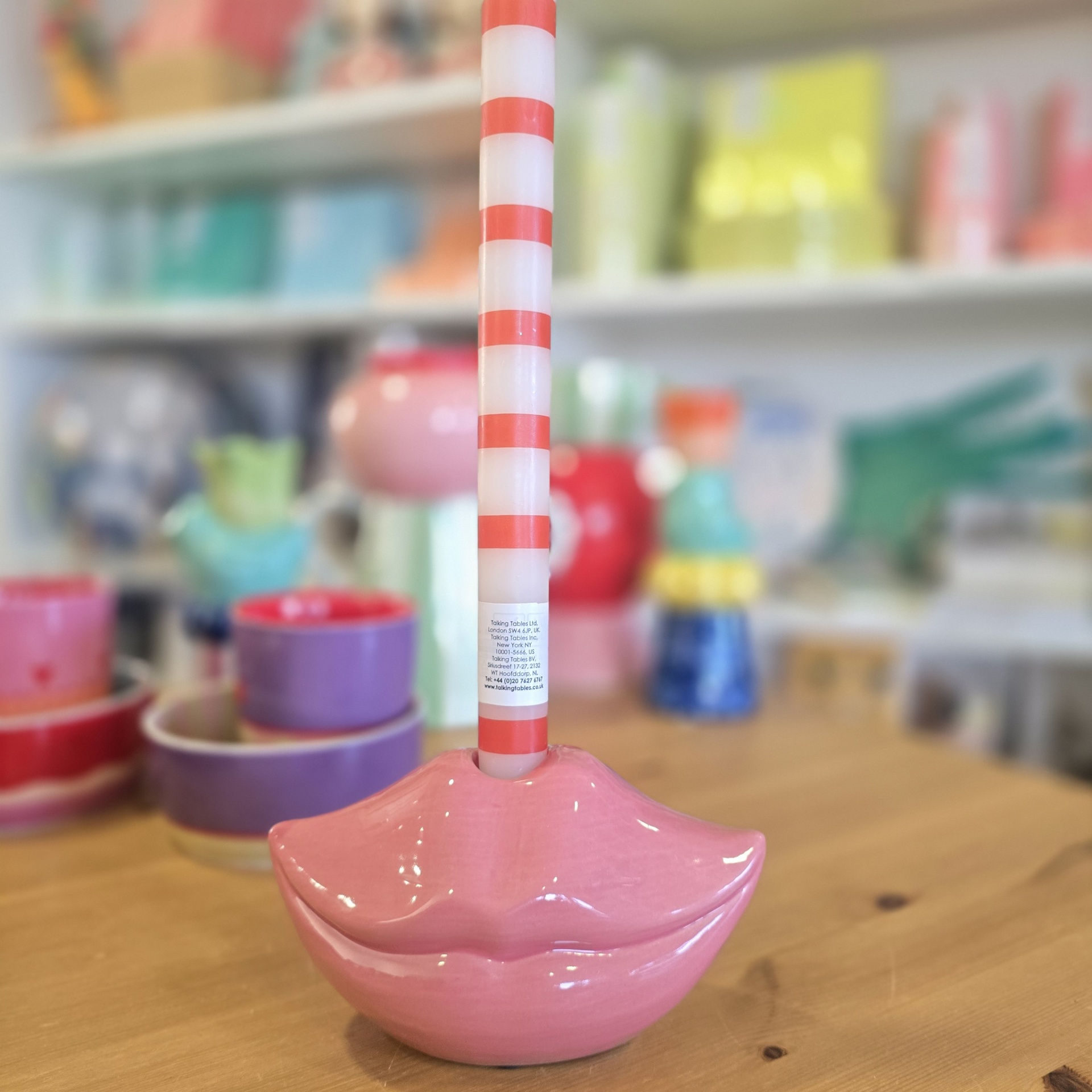 Escova de casa de banho com base rosa em forma de lábios e cabo com riscas vermelhas