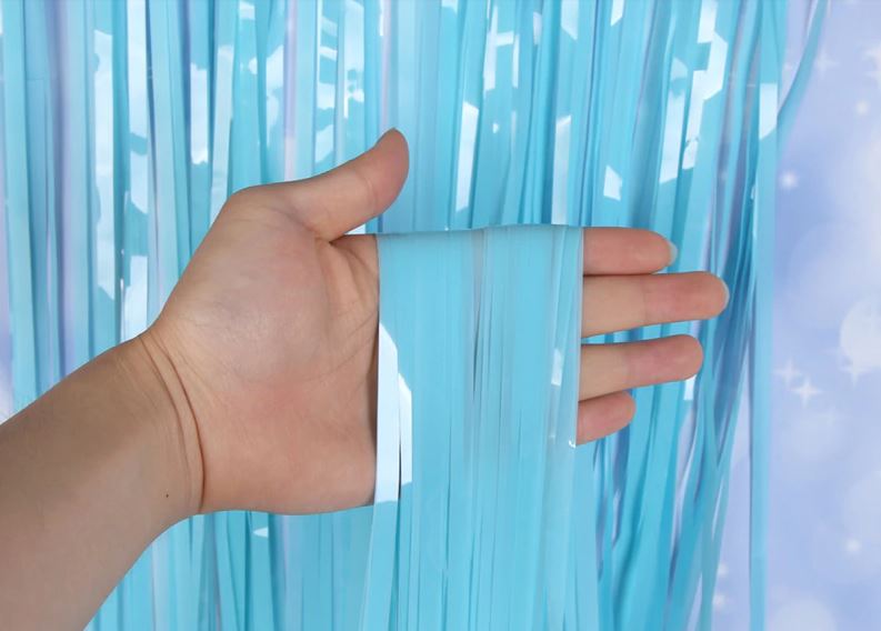 Mão segurando cortina azul brilhante de tiras prateadas