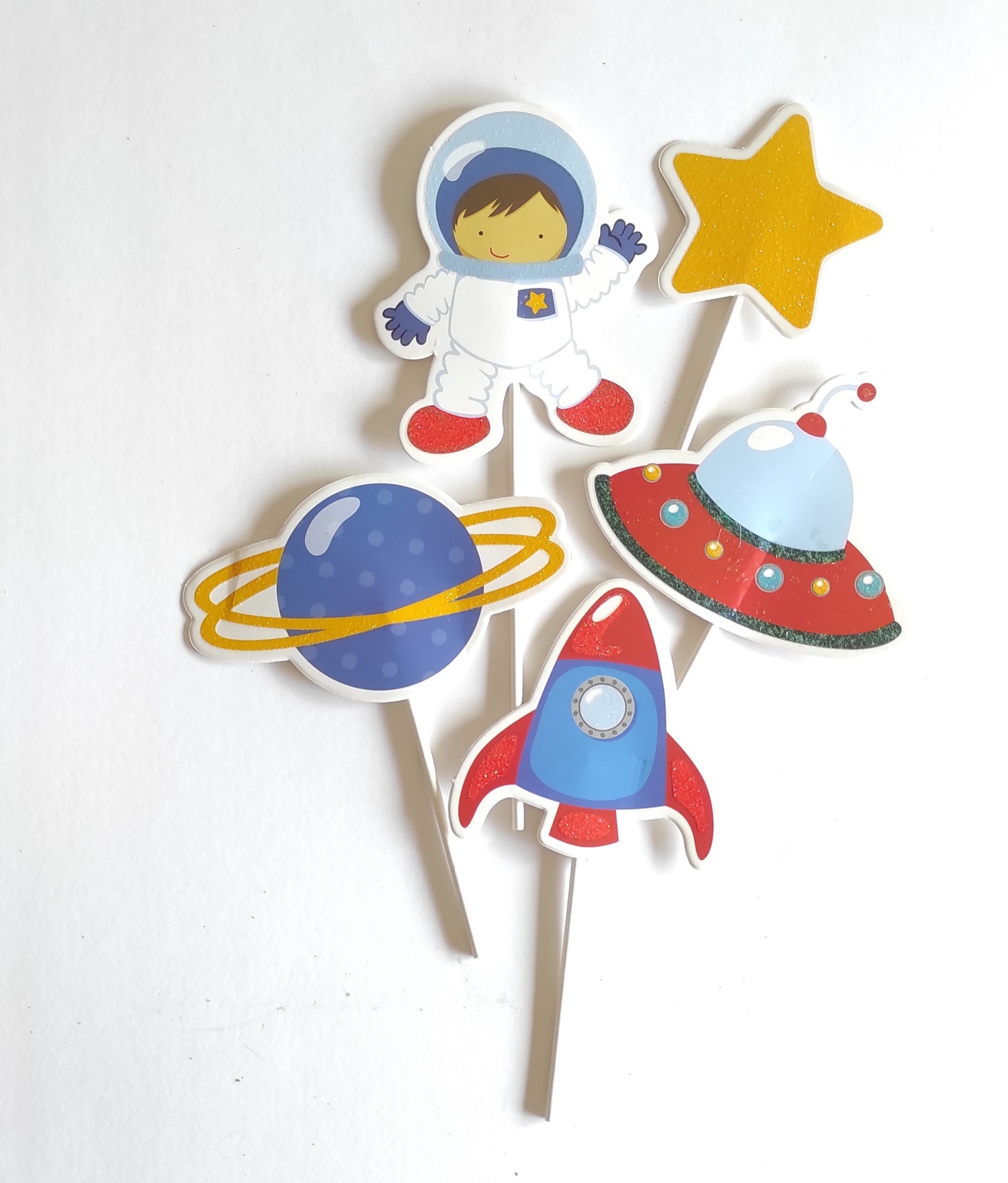 Toppers decorativos de papel com tema espacial: astronauta, estrela, planeta, foguetão e nave espacial.