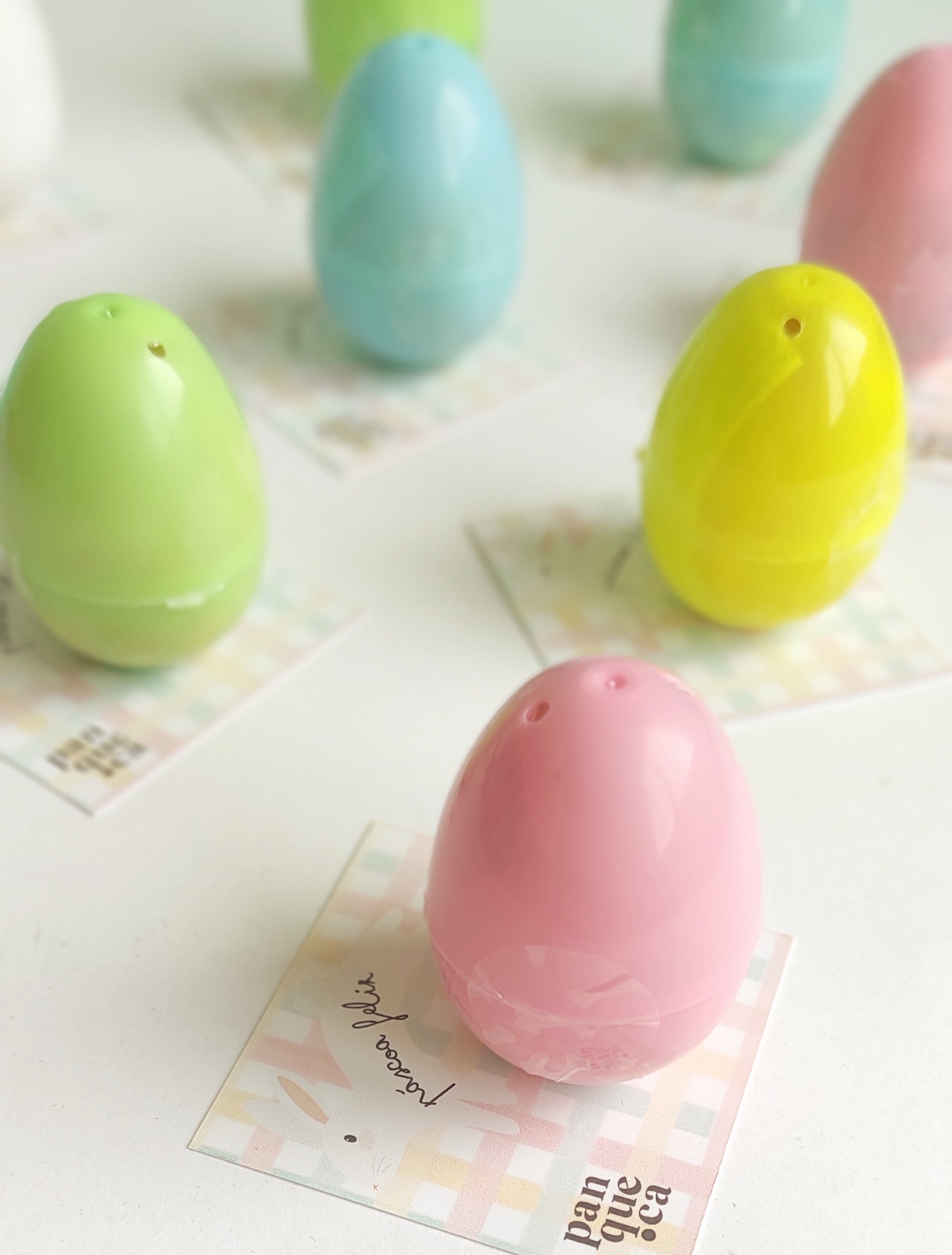 Molhos ou saleiros em forma de ovos coloridos sobre cartões estampados