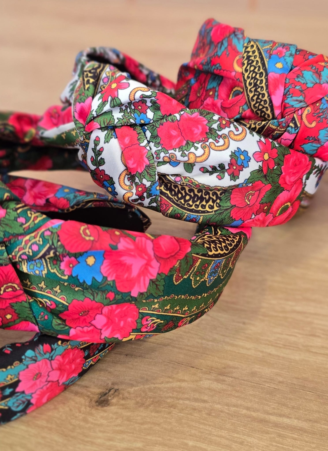 Tiaras de tecido com padrão floral colorido em superfície de madeira clara