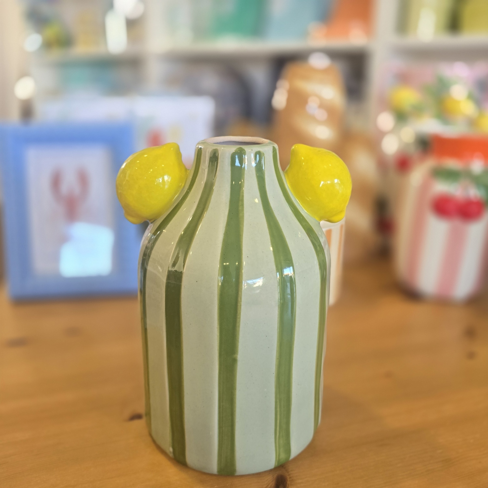 Vaso decorativo em cerâmica com riscas verticais verdes e limas amarelas nas laterais