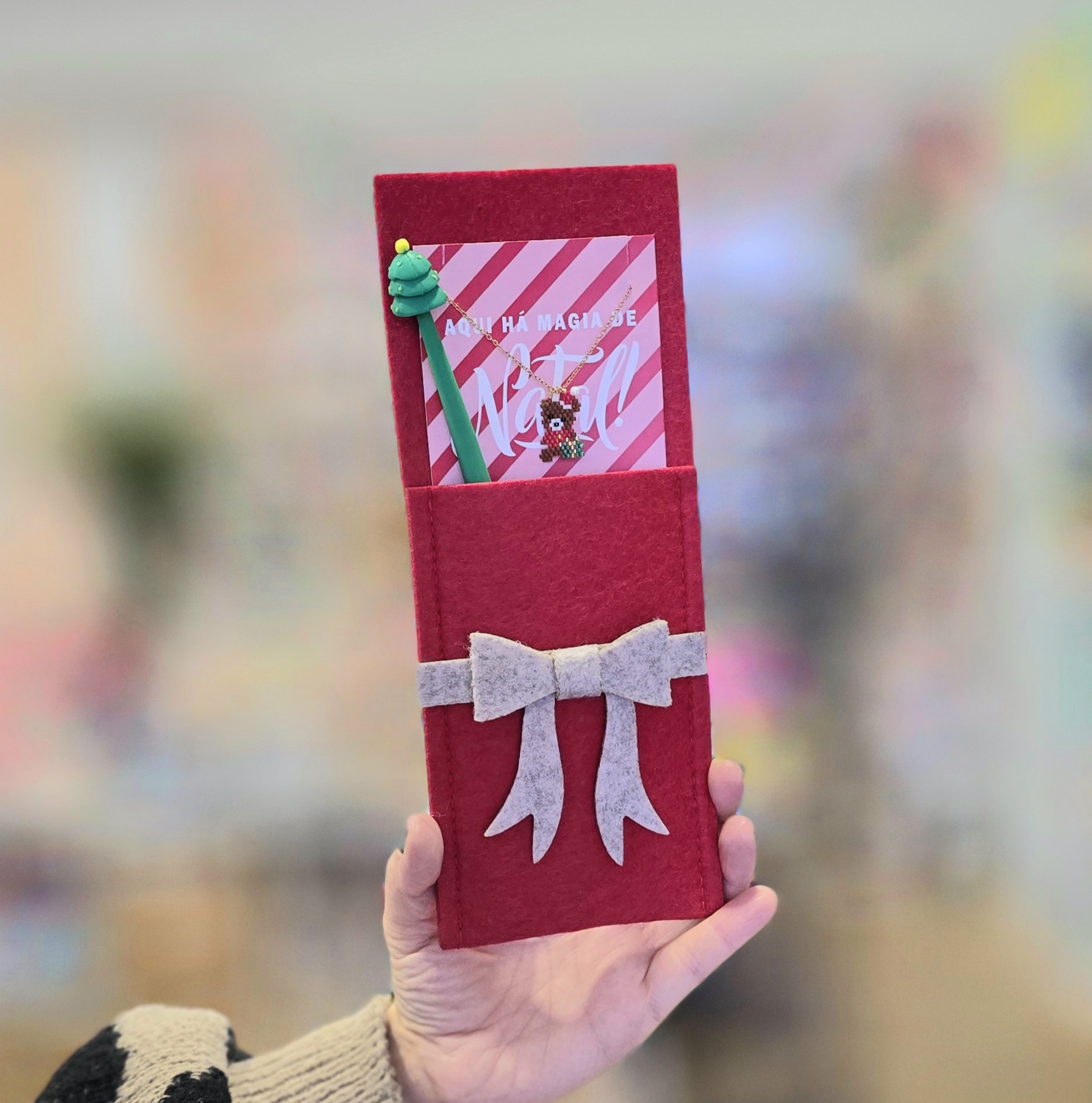 Estojo vermelho com laço cinza, cartão decorativo, colar de rena e caneta de árvore de Natal