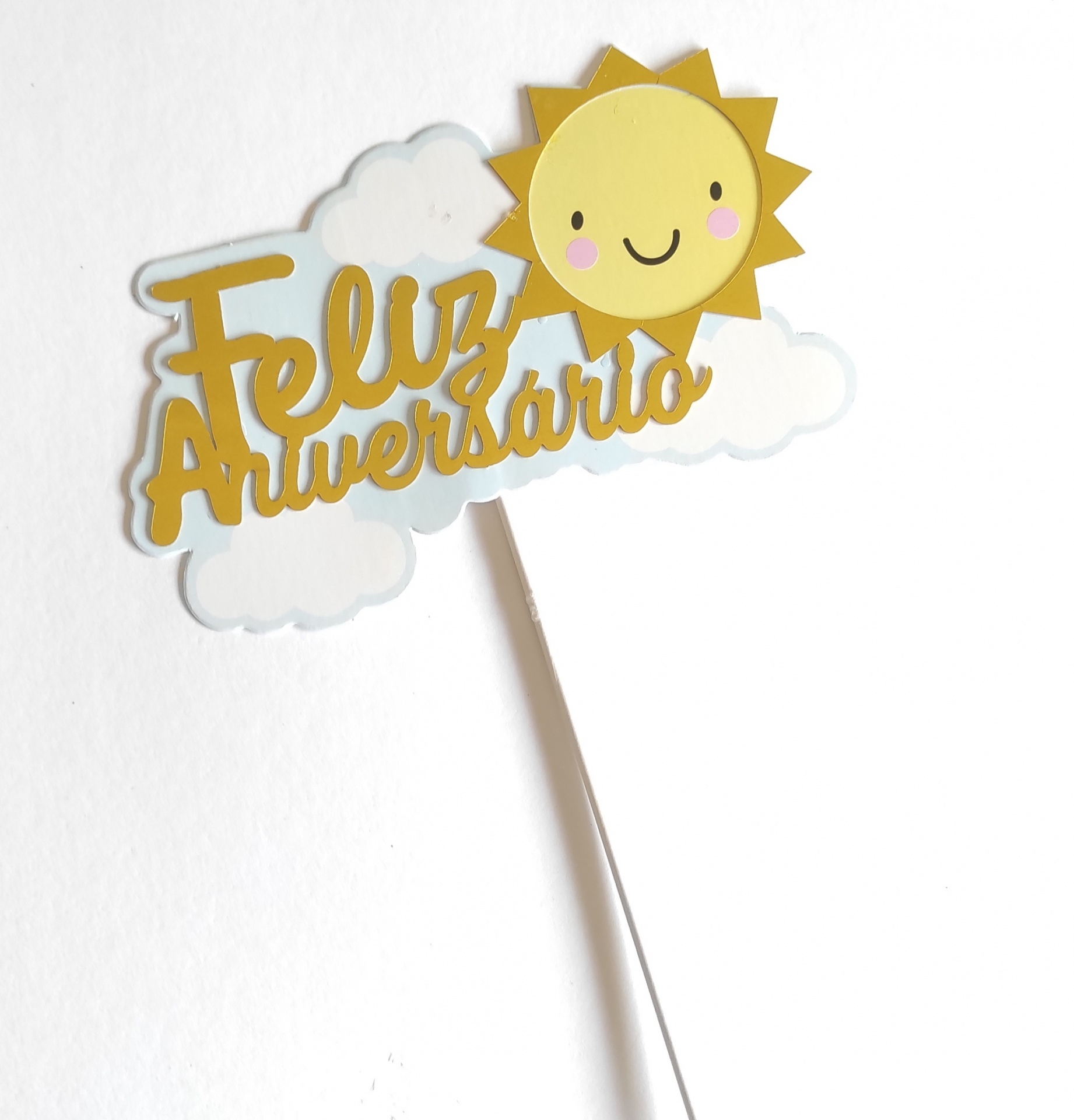 Placa decorativa de aniversário com texto 'Feliz Aniversário' em amarelo e desenho de sol e nuvens.
