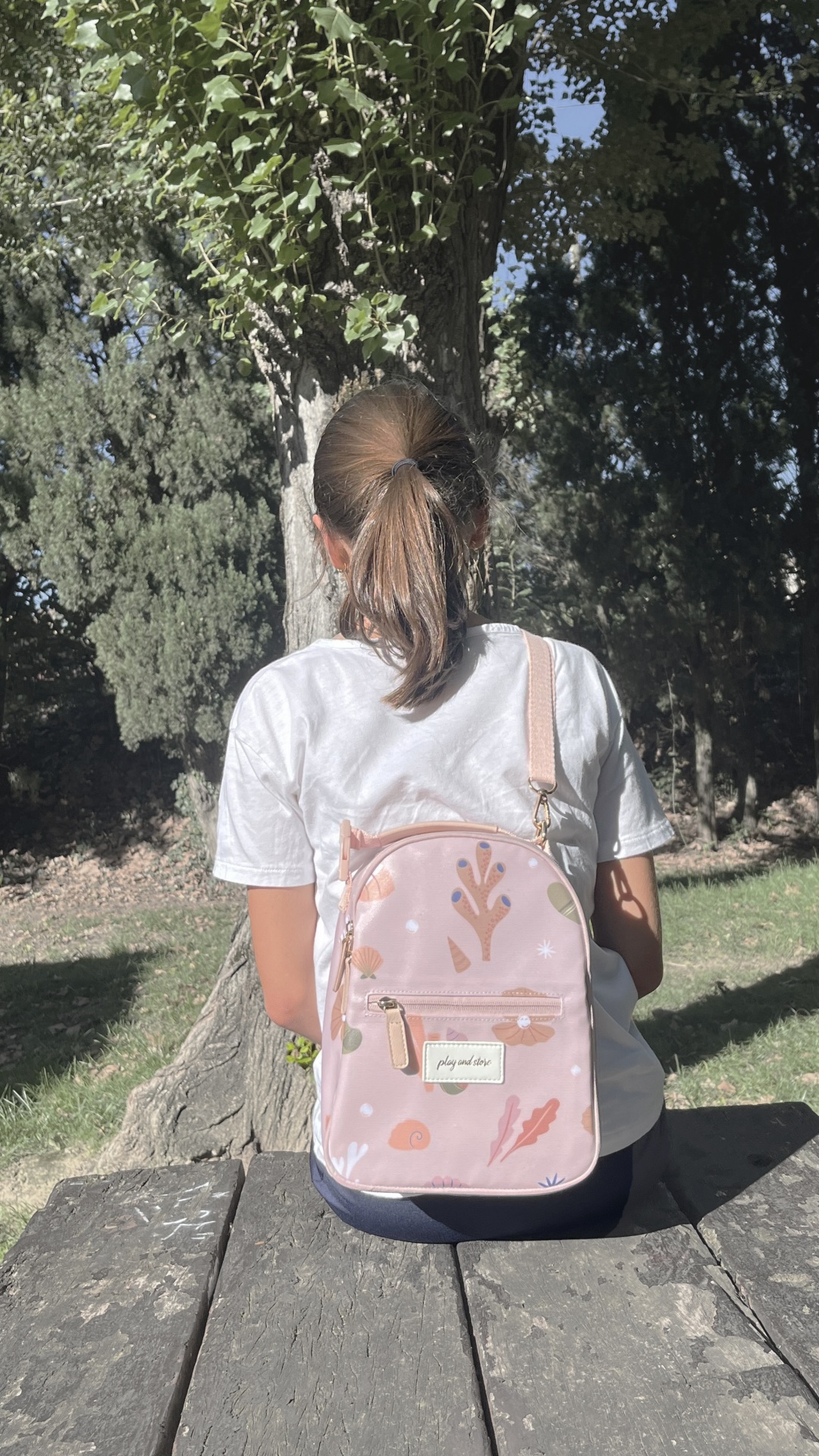 Mochila rosa claro com padrões coloridos usada ao ar livre