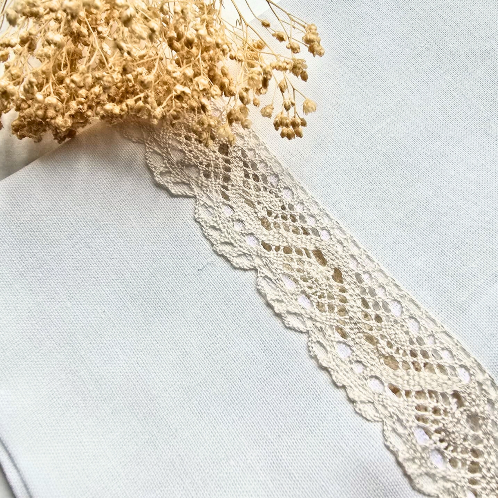 Toalha branca com bordado de renda creme e flores secas