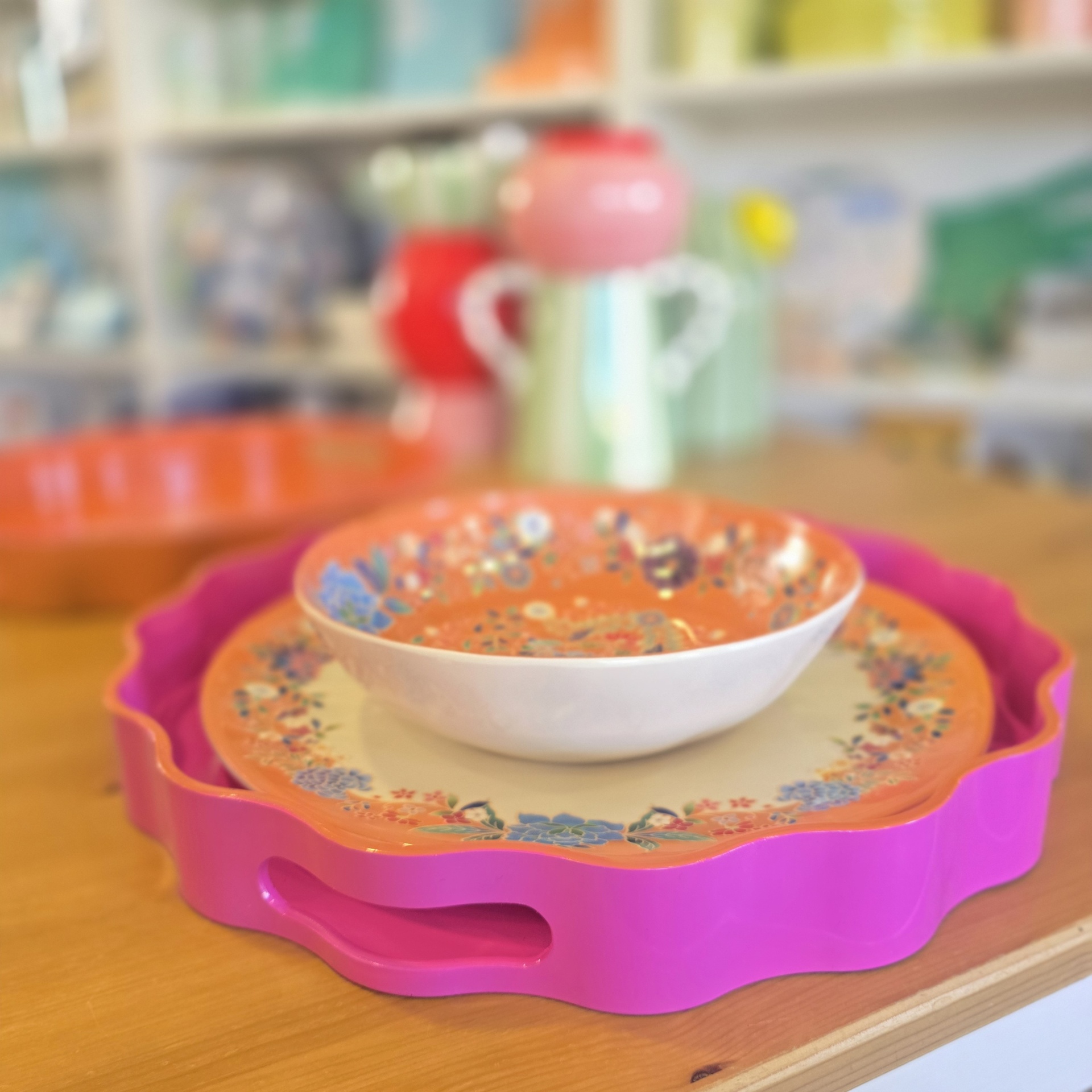 Conjunto de loiça floral em tabuleiro rosa em mesa de madeira