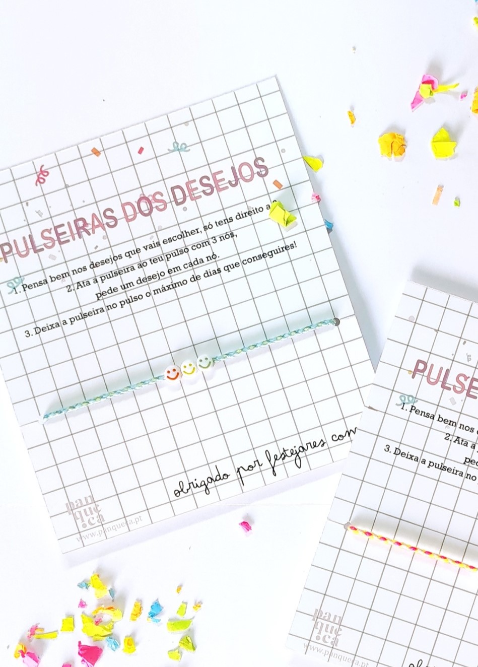 Cartões com padrão de quadrícula contendo pulseiras de missangas e texto em português com instruções, sobre superfície branca com confetes coloridos.
