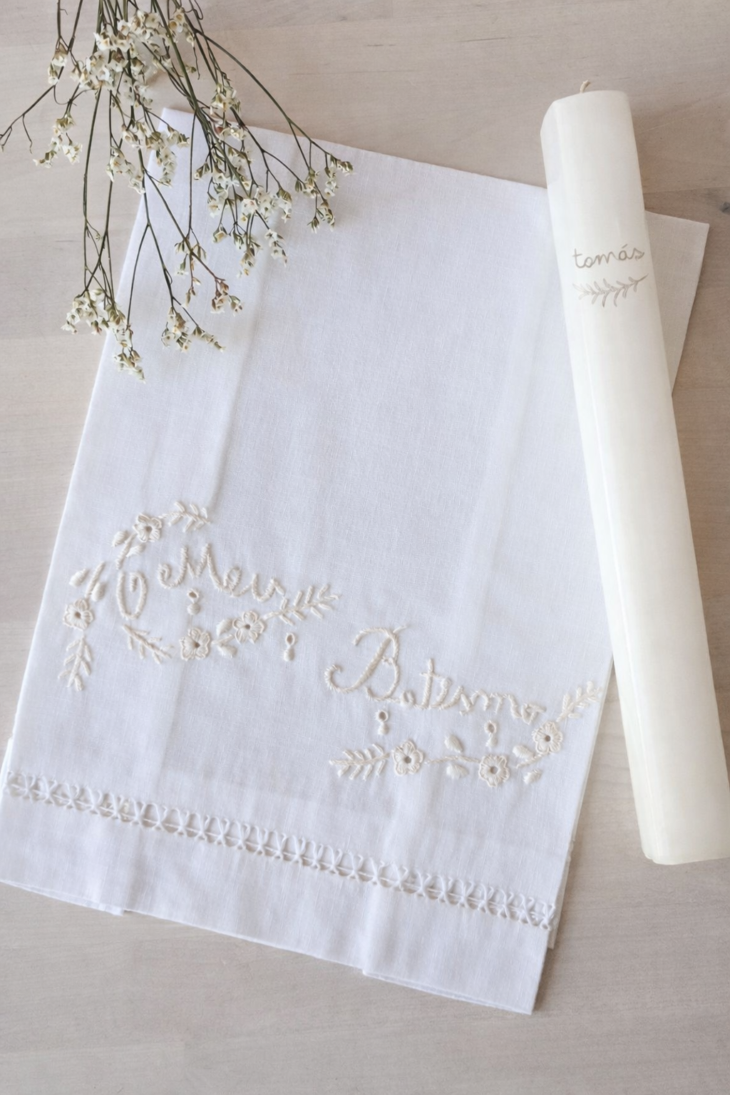 Toalha branca bordada com texto O Meu Batismo e vela branca com nome tomás