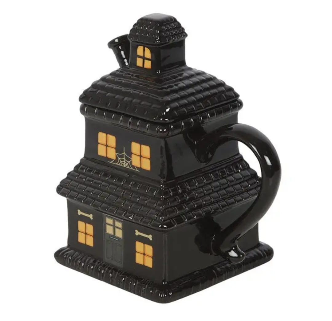 Caneca de cerâmica em forma de casa assombrada preta com janelas laranja e desenhos de ossos