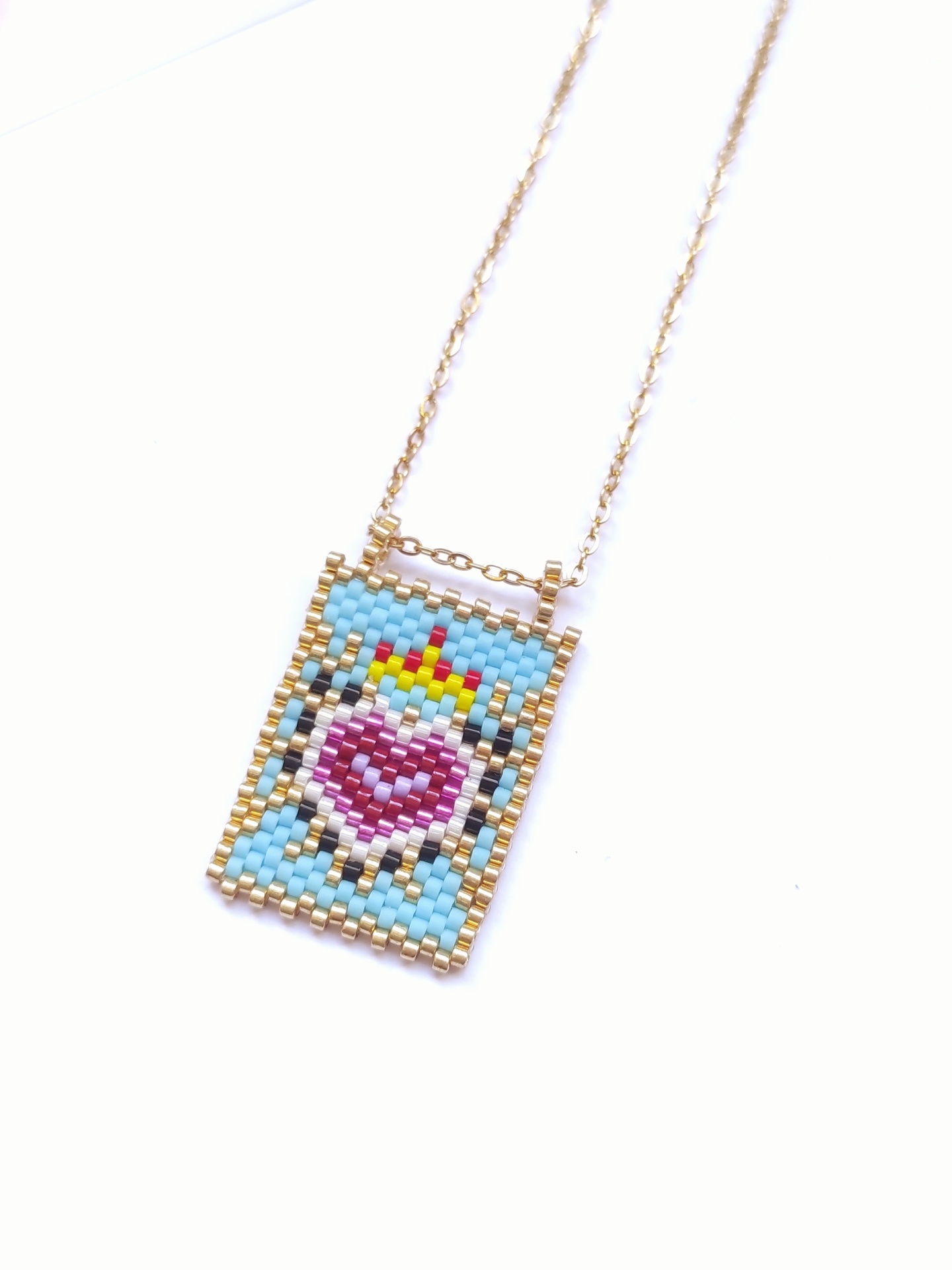 Colar com pendente retangular em contas coloridas e corrente dourada