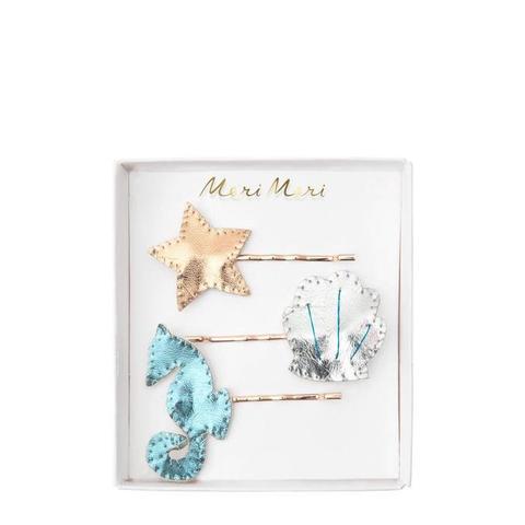 Conjunto de três ganchos de cabelo com estrela dourada, concha prateada e cavalo-marinho azul em embalagem branca