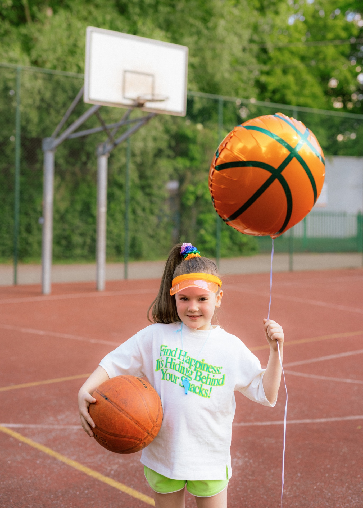 Criança com bola e balão de basquetebol em campo ao ar livre