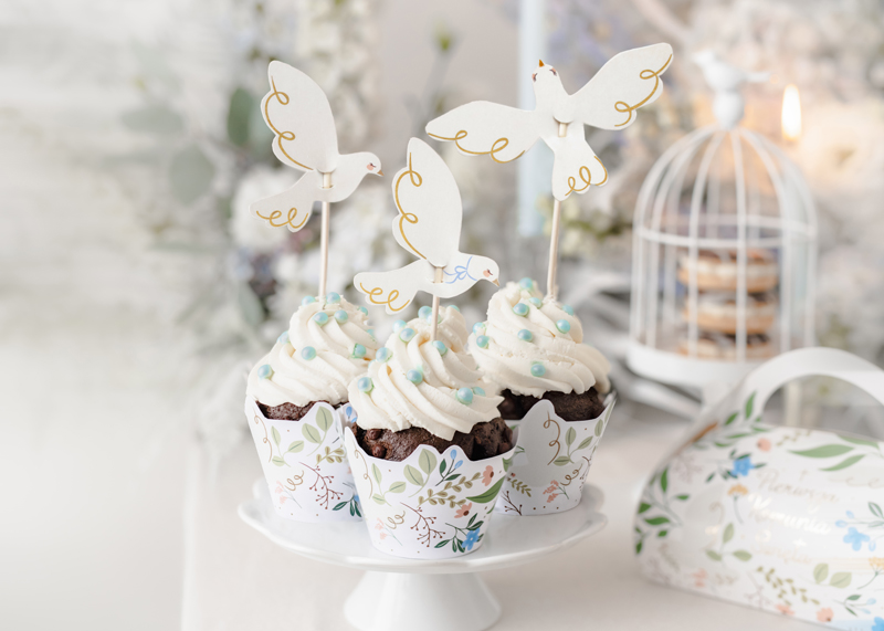 Três cupcakes decorados com pombas brancas em suporte branco