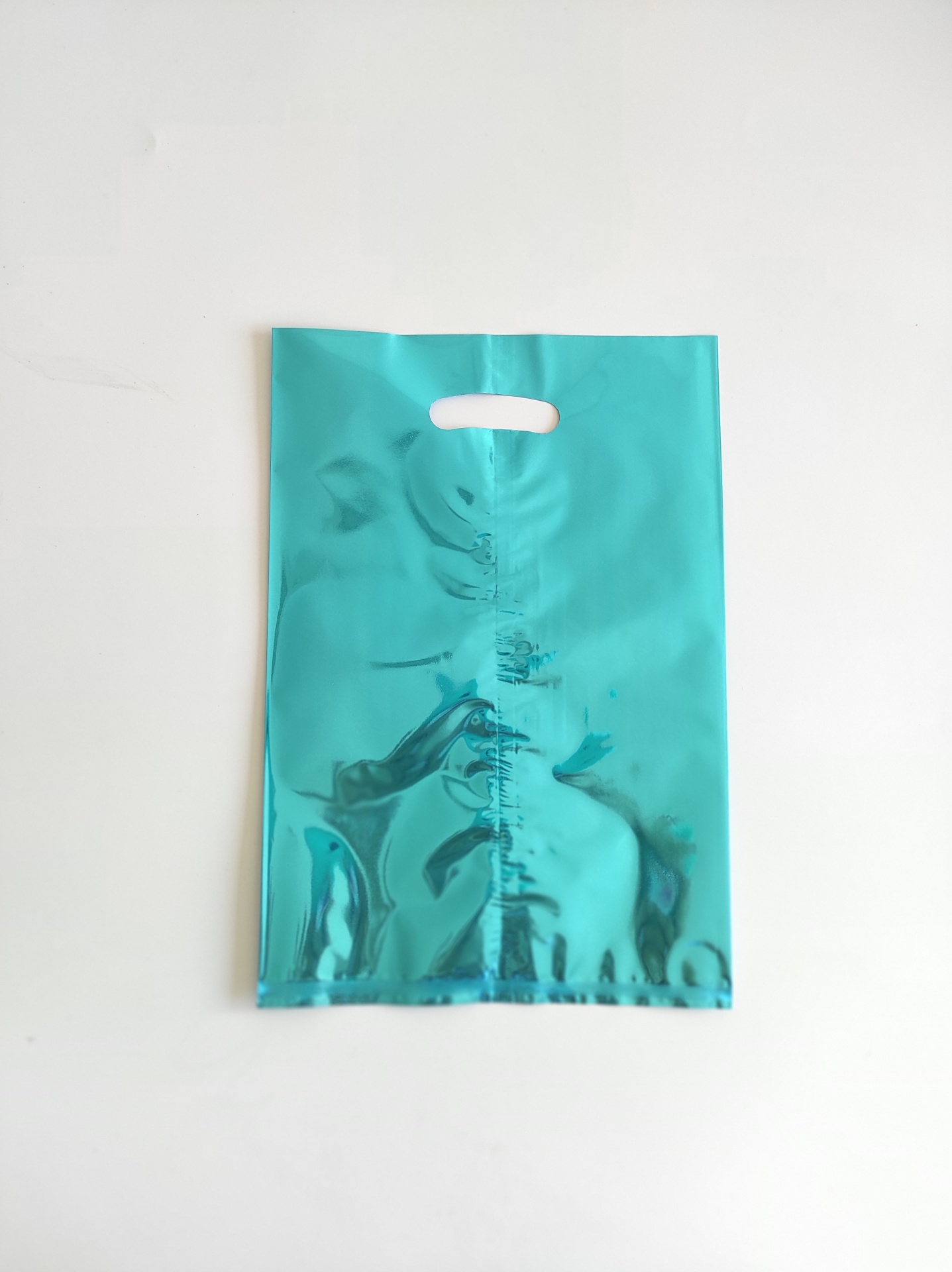 Saco plástico azul metálico brilhante com alça recortada