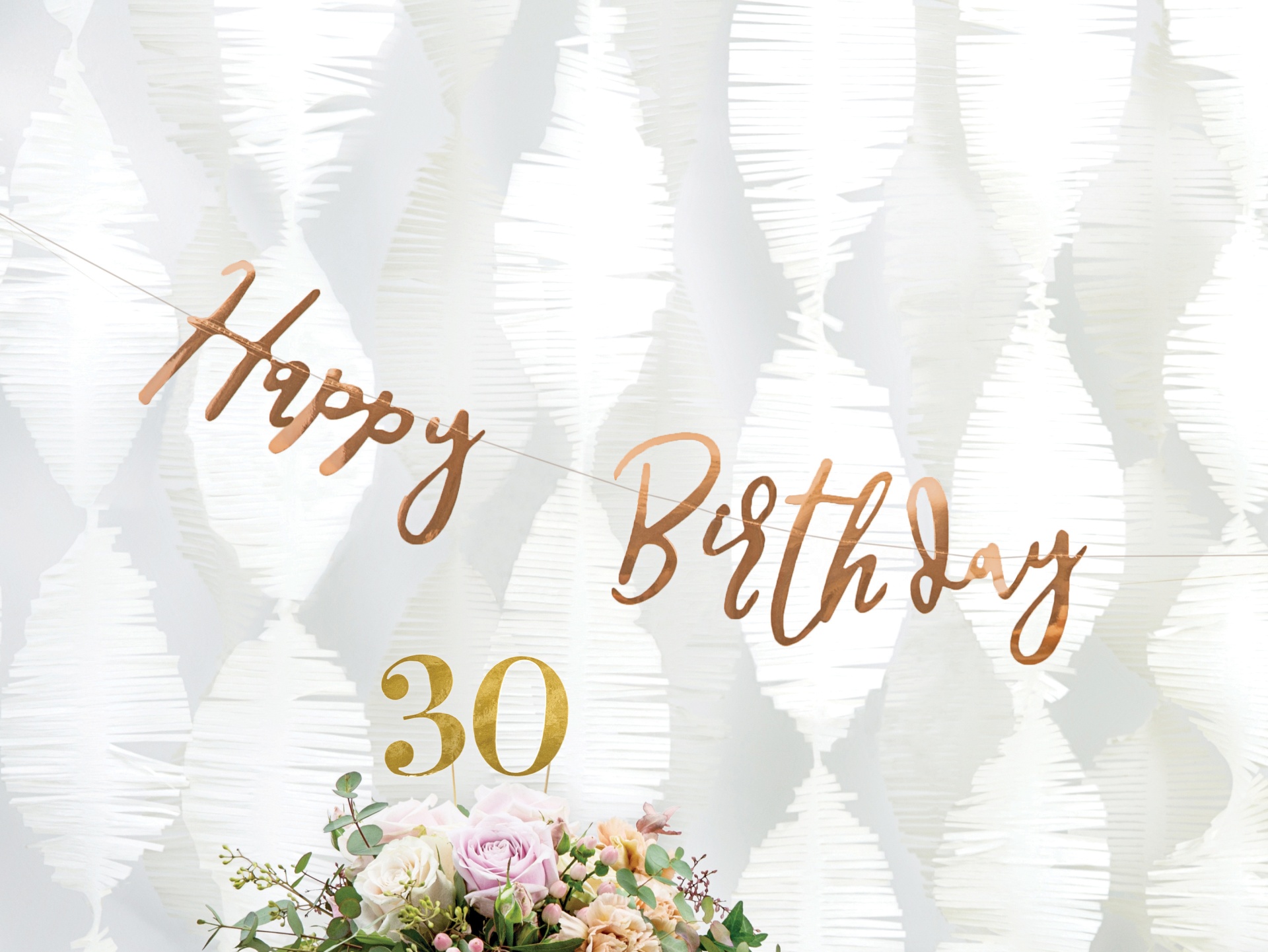 Decoração de aniversário com 'Happy Birthday' e número 30 dourado sobre fundo branco e flores