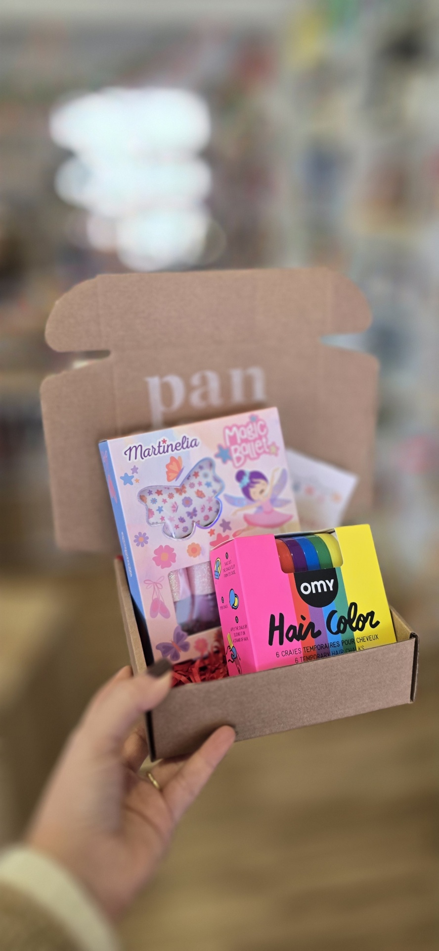 Caixa de cartão com brinquedos coloridos e embalagens de papel