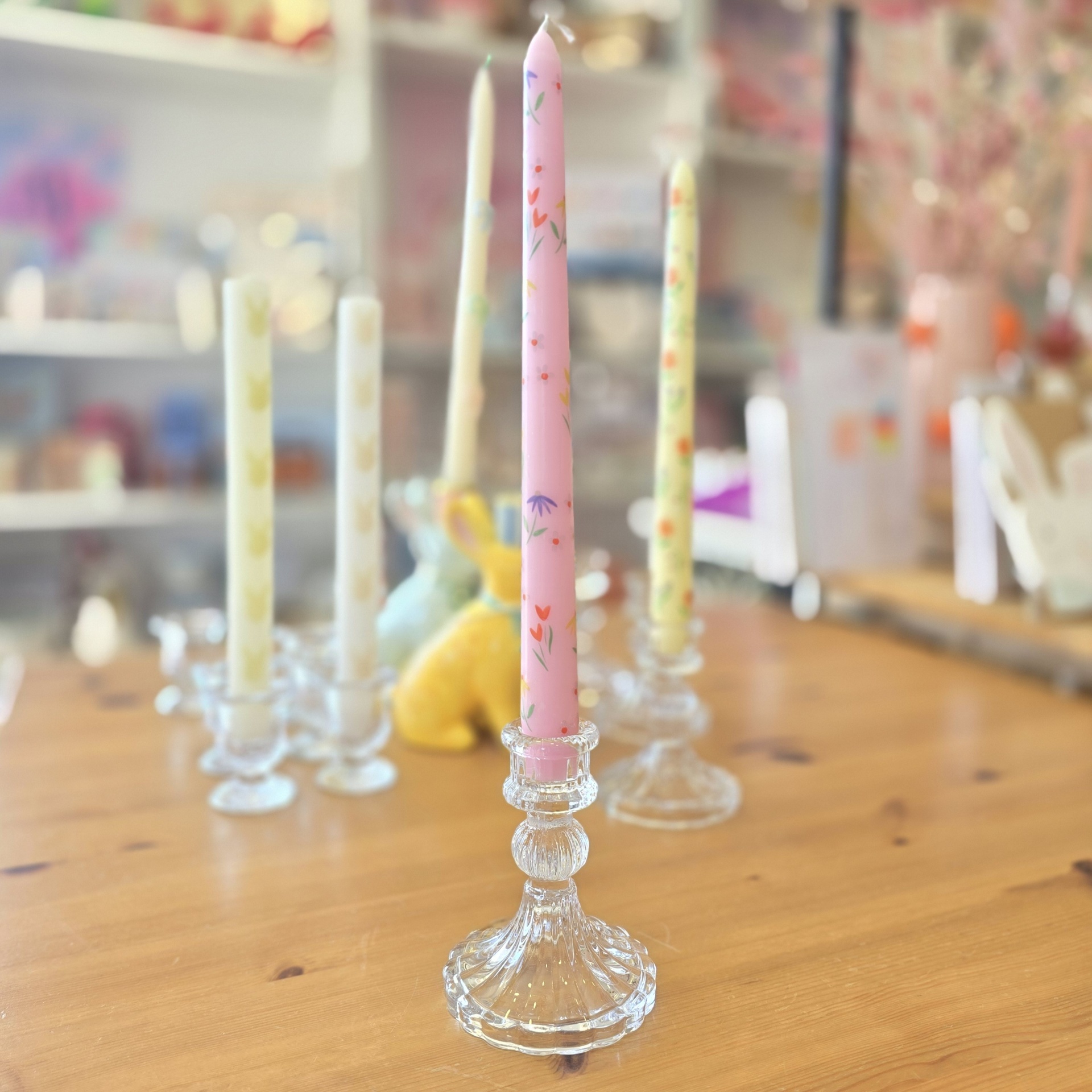 Castiçais de vidro com velas coloridas e decoradas