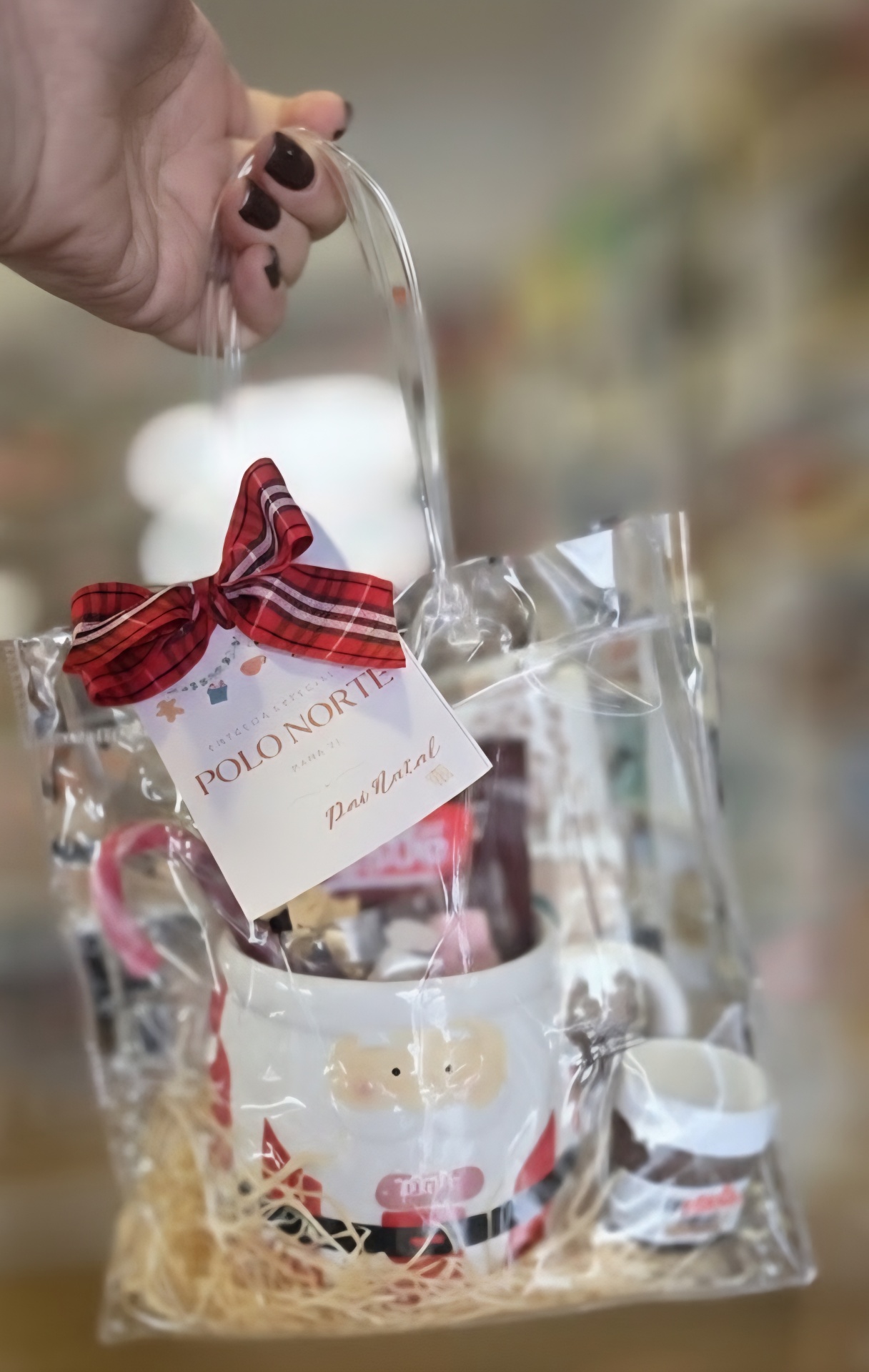 Saco transparente com caneca estampada de Pai Natal, palha, laço vermelho e etiqueta Polo Norte Pai Natal