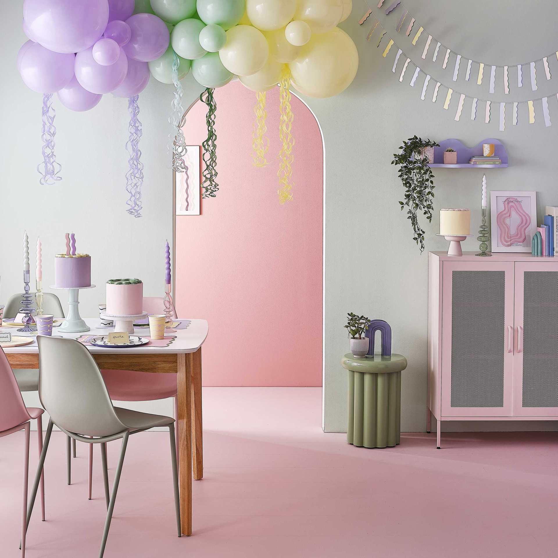 Sala decorada com balões coloridos e mobília em tons pastel e rosa