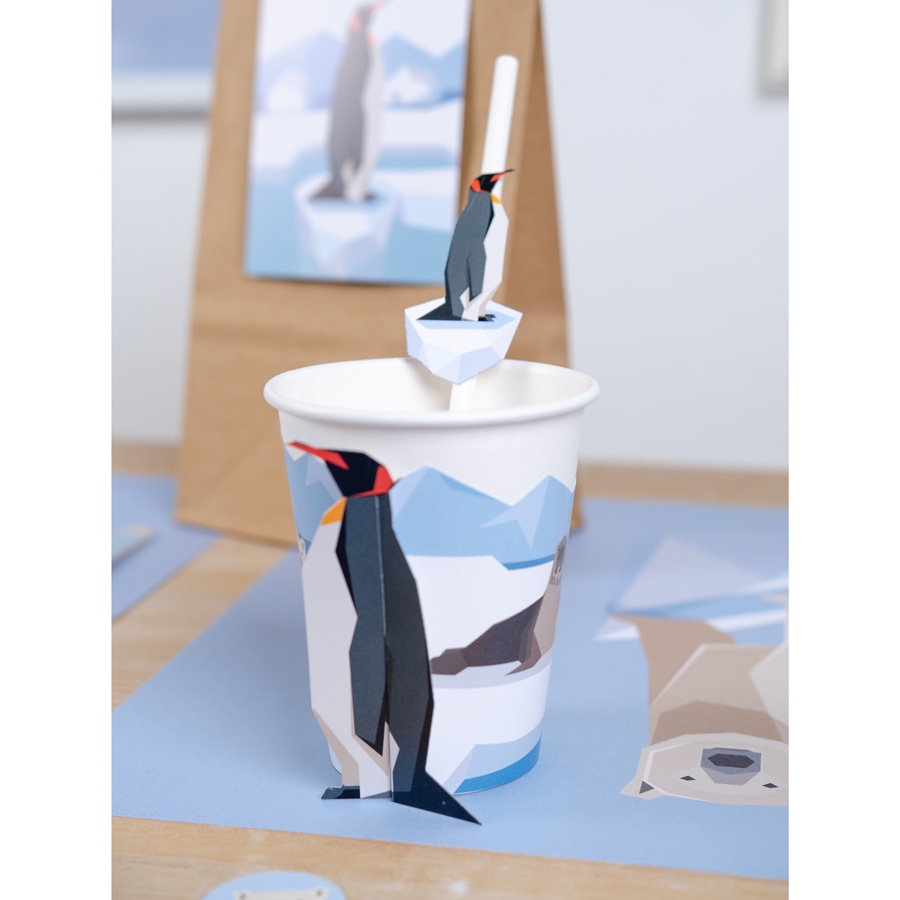 Copo de papel com ilustração de pinguim e enfeite de papel do mesmo tema