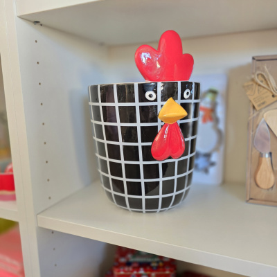 Pote decorativo cerâmica com padrão xadrez e figura de galinha na prateleira branca