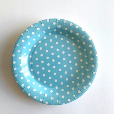 Prato descartável azul com bolinhas brancas sobre fundo branco