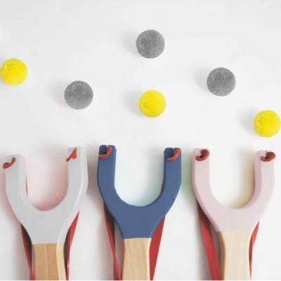 Três estilingues coloridos com bolas coloridas no fundo branco