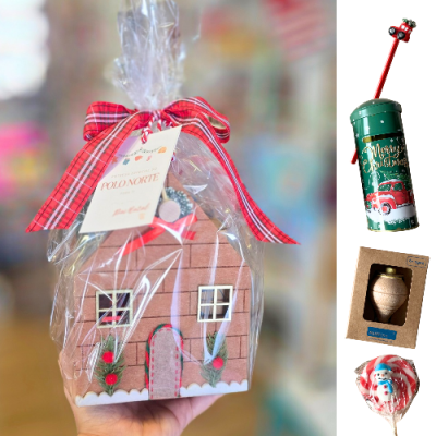 Casinha de Natal em madeira pintada, embrulhada com fita vermelha xadrez.