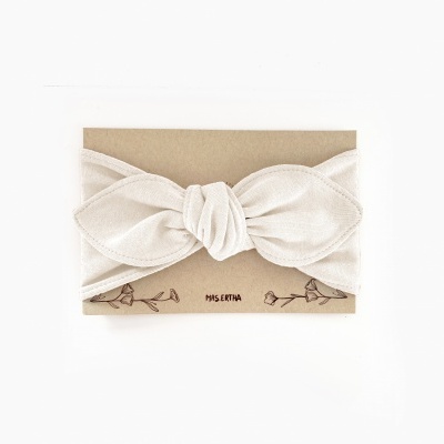 Faixa de cabelo branca com nó em cartão castanho com desenhos florais