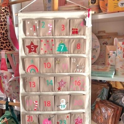 Calendário de advento em tecido com bolsos numerados e desenhos natalícios