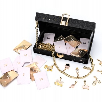 Caixa preta com corrente dourada, envelopes numerados e pendentes dourados