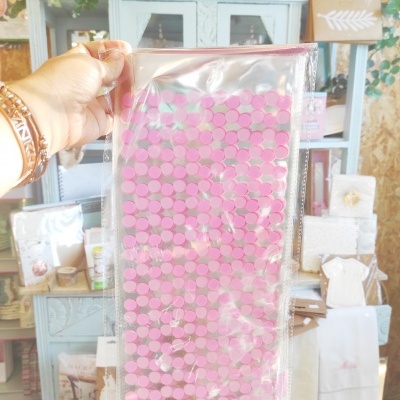 Saco transparente com pequenos círculos rosa, fundos com móveis e decoração clara