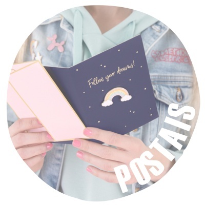 Cartão postal azul escuro com arco-íris e texto 'Follow your dreams!' nas mãos de uma pessoa vestindo casaco de ganga