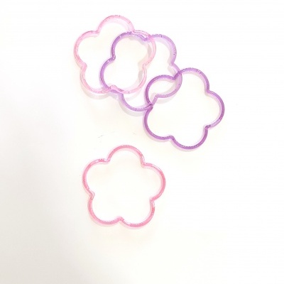 Elásticos para cabelo em forma de flor, cores rosa e roxo, fundo branco.